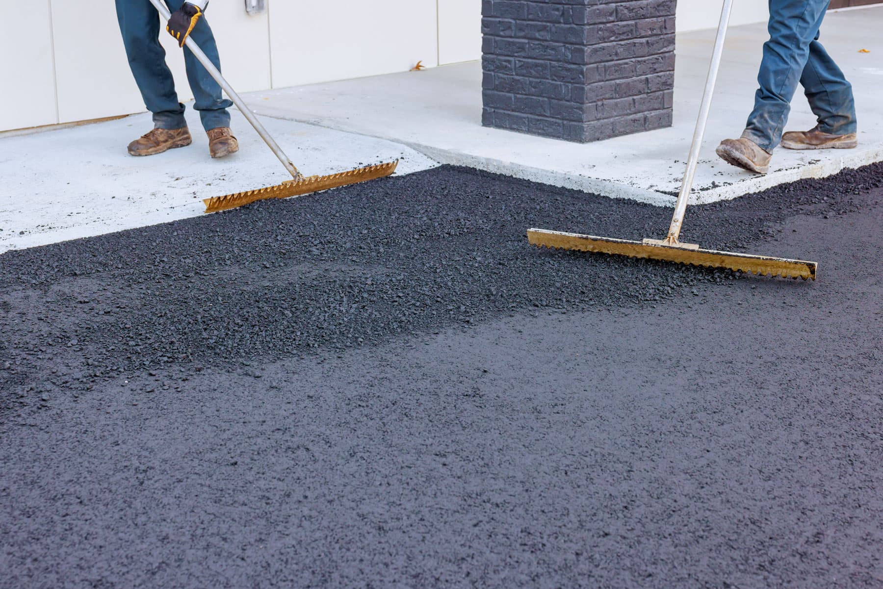 Crew spreading fresh asphalt on a residential driveway in Surrey BC