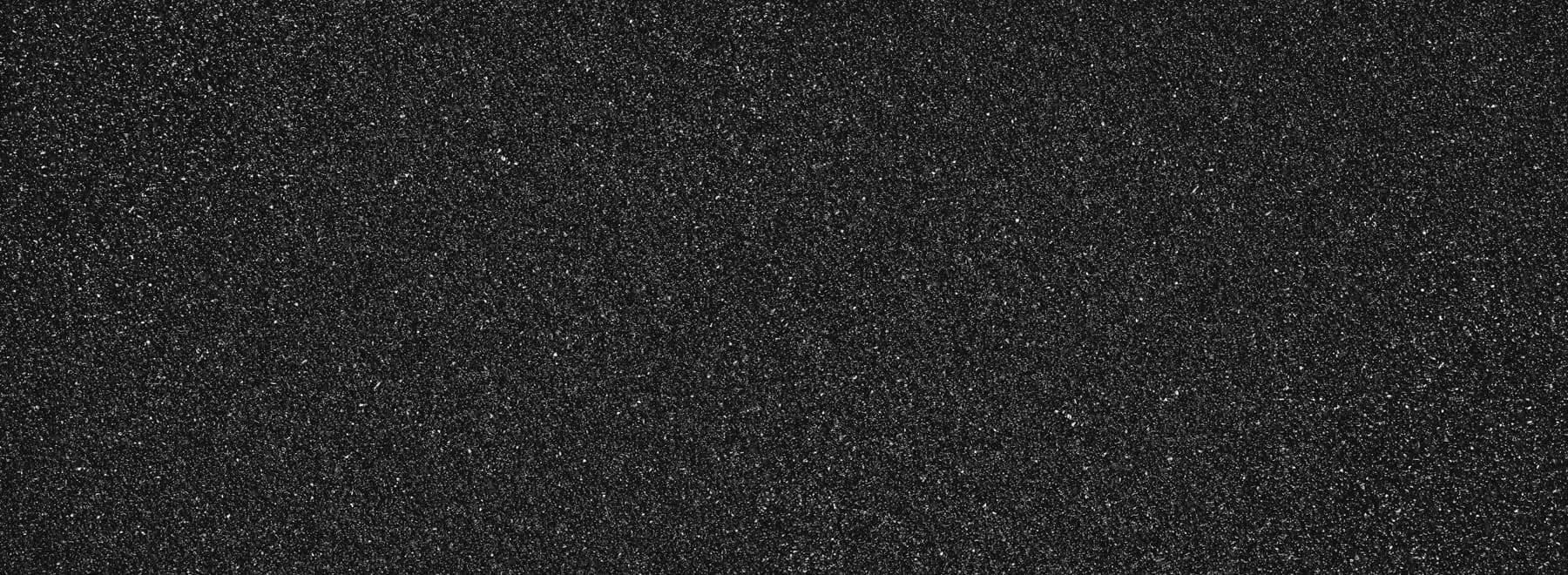Close-up of asphalt surface texture showing early cracking on a Surrey driveway